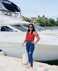 a woman standing in front of a white boat