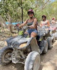 four women riding atvs on a trail in the jungle
